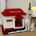 A cozy tabby cat snuggled up inside the McDonald's-themed pet bed, enjoying a restful nap.