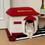 A cozy tabby cat snuggled up inside the McDonald's-themed pet bed, enjoying a restful nap.