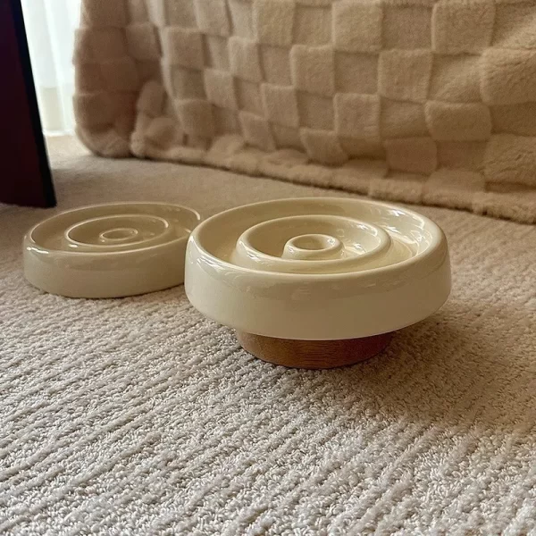 Side view of the ceramic slow feeder cat bowl with a raised wooden stand for better posture.
