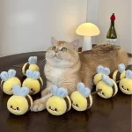 A happy cat playing with the bee-shaped Matatabi toy, kicking and batting it around.
