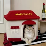 A cozy tabby cat snuggled up inside the McDonald's-themed pet bed, enjoying a restful nap.
