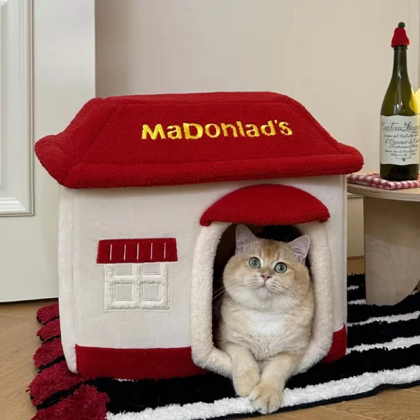 A cozy tabby cat snuggled up inside the McDonald's-themed pet bed, enjoying a restful nap.